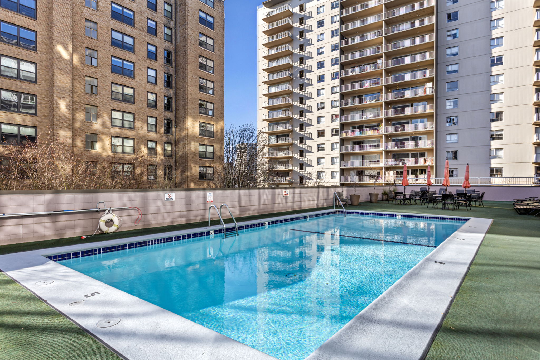 The gated outdoor pool and sun deck—with tables and seating—is an easy place to spend a sunny afternoon.