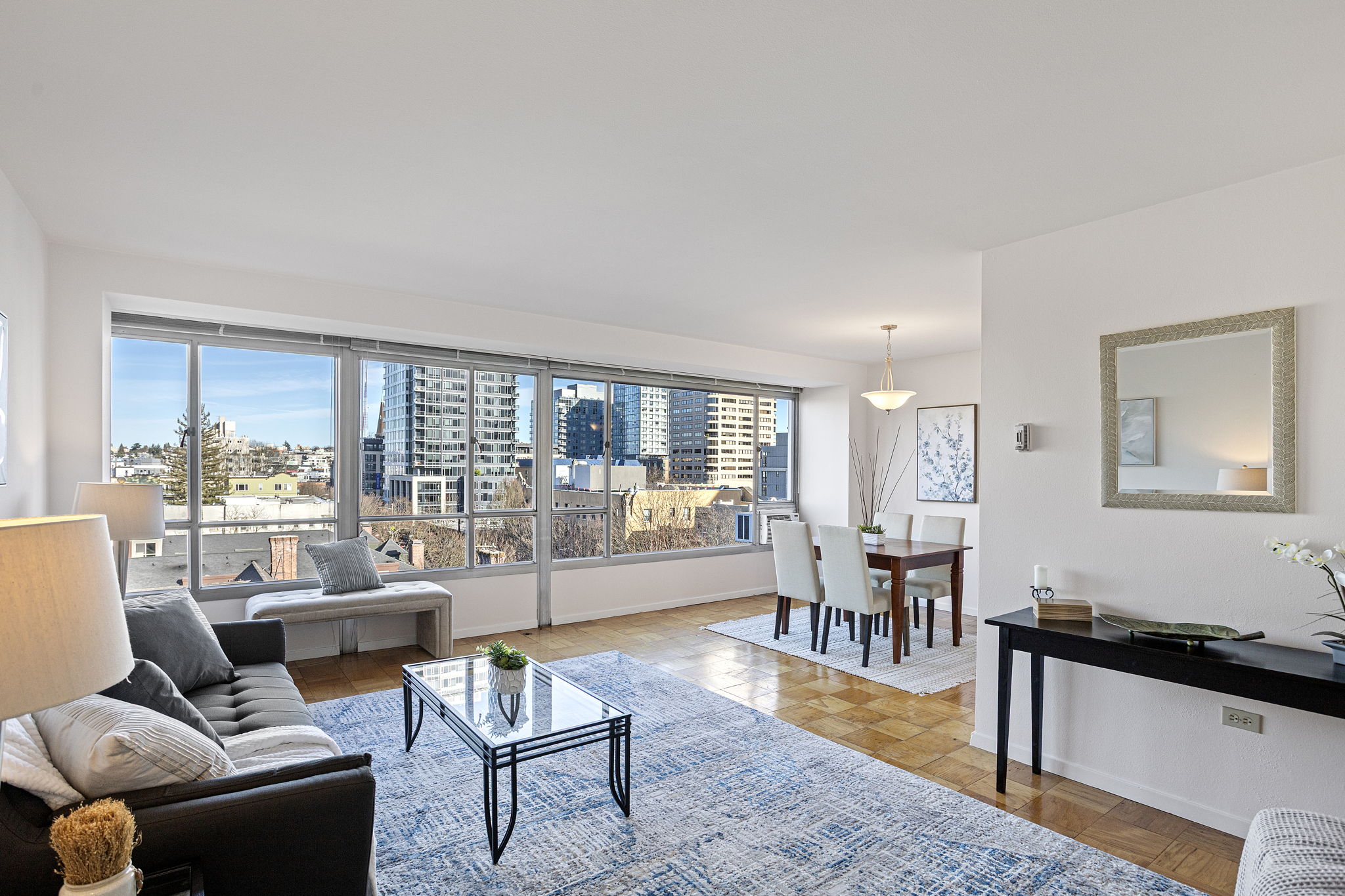 Eighth-floor light and a wide window wall make the living room feel open and easy, with a calm First Hill outlook beyond.