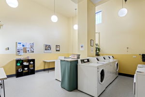 Bright, well-maintained common laundry with modern machines and generous folding space.