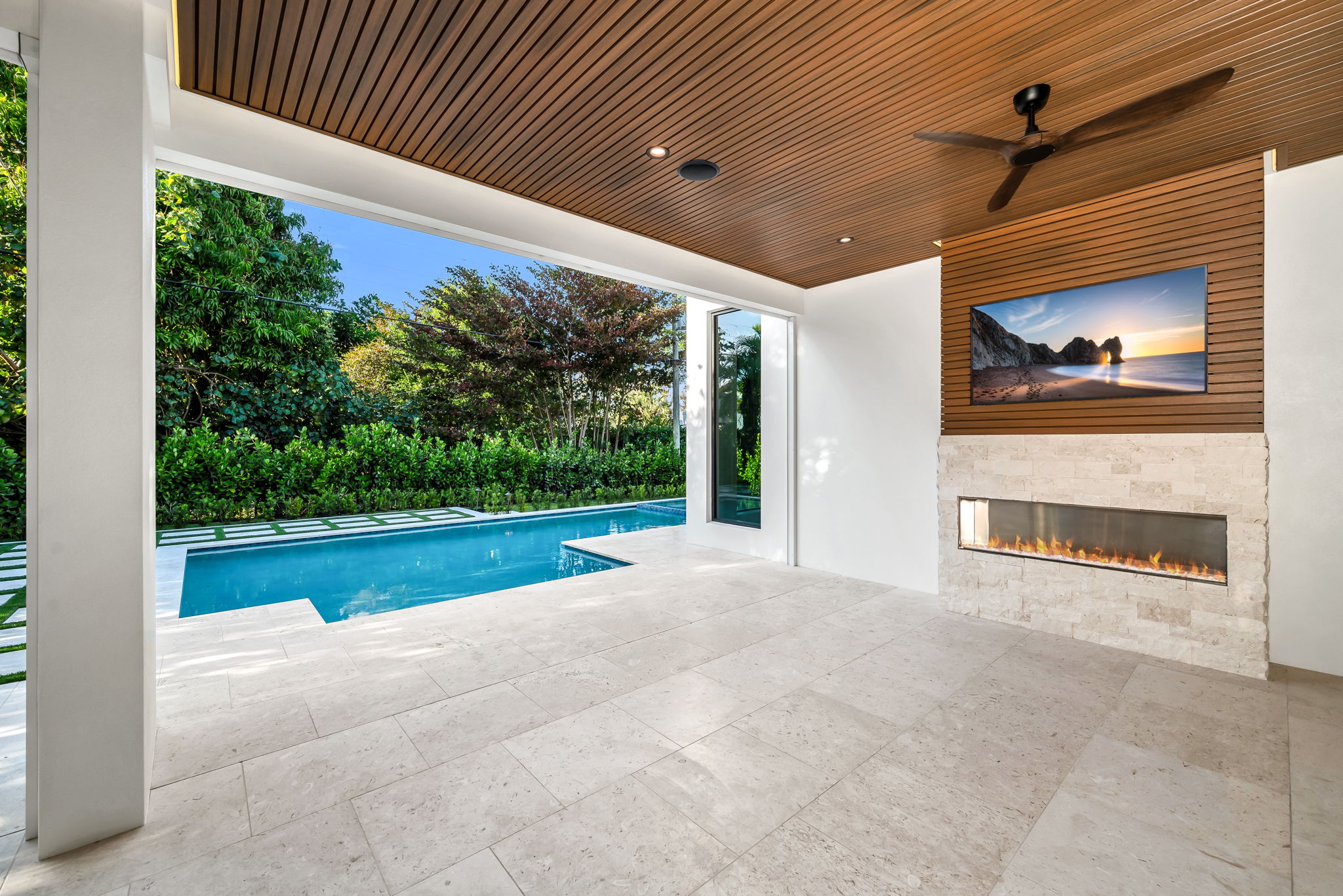 View 2 - Covered lanai with low-voltage lighting, composite woodwork, gas fireplace, and summer kitchen.