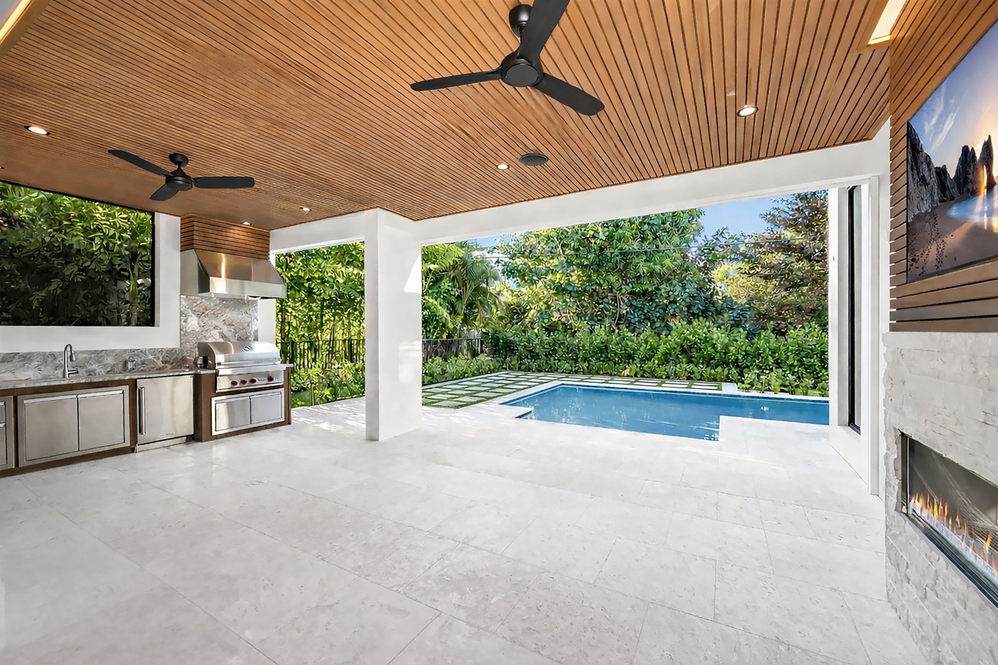 View 1 - Covered lanai with low-voltage lighting, composite woodwork, gas fireplace, and summer kitchen.