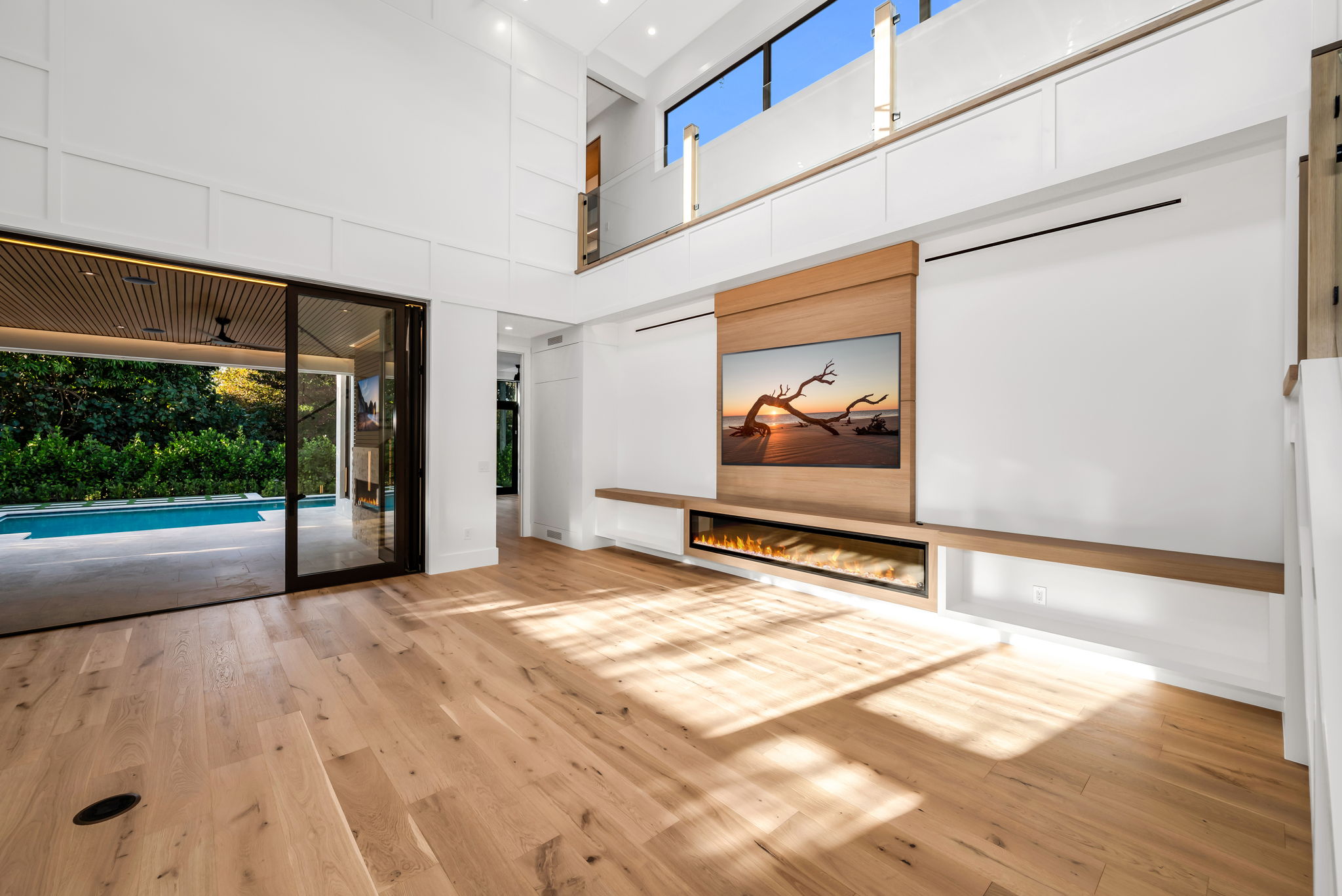 View 2 - Open living area overlooking the pool, highlighted by soaring 22’ ceilings and an airy, expansive feel.