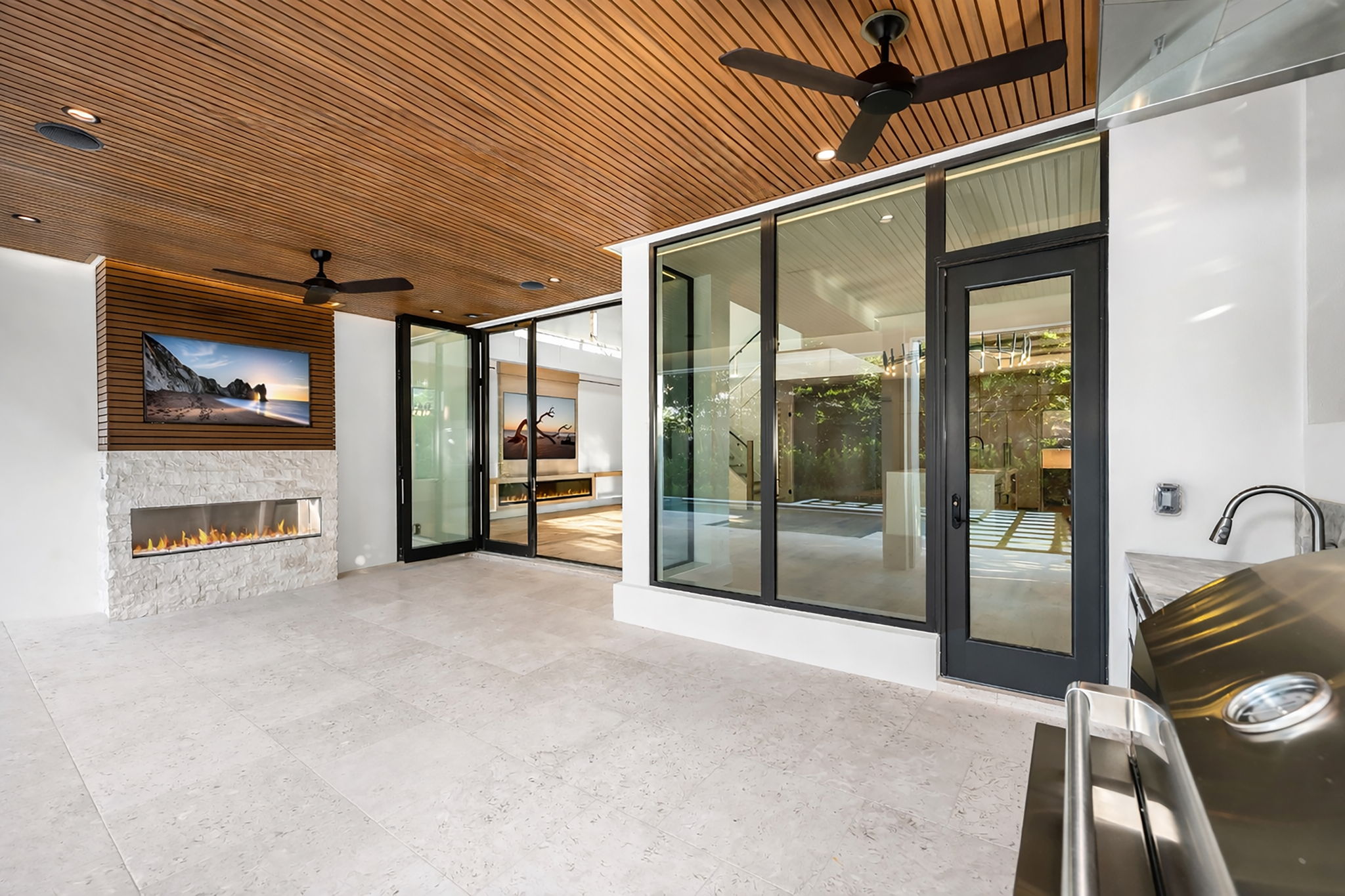 View 3 - Covered lanai with low-voltage lighting, composite woodwork, gas fireplace, and summer kitchen.