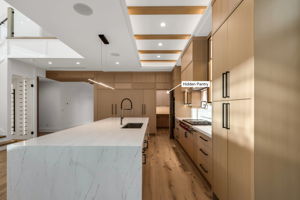 Custom white oak cabinetry with a seamlessly hidden pantry for a clean, elevated look.