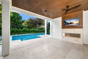 View 2 - Covered lanai with low-voltage lighting, composite woodwork, gas fireplace, and summer kitchen.