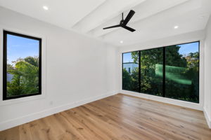 Upstairs primary suite overlooking the pool, complete with a private balcony retreat.