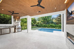 View 1 - Covered lanai with low-voltage lighting, composite woodwork, gas fireplace, and summer kitchen.
