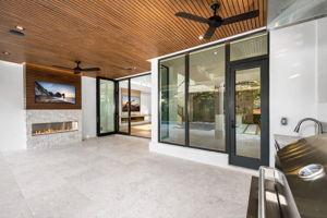 View 3 - Covered lanai with low-voltage lighting, composite woodwork, gas fireplace, and summer kitchen.