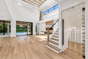 Custom under-stairs wine storage illuminated with low-voltage lighting — a true statement piece!