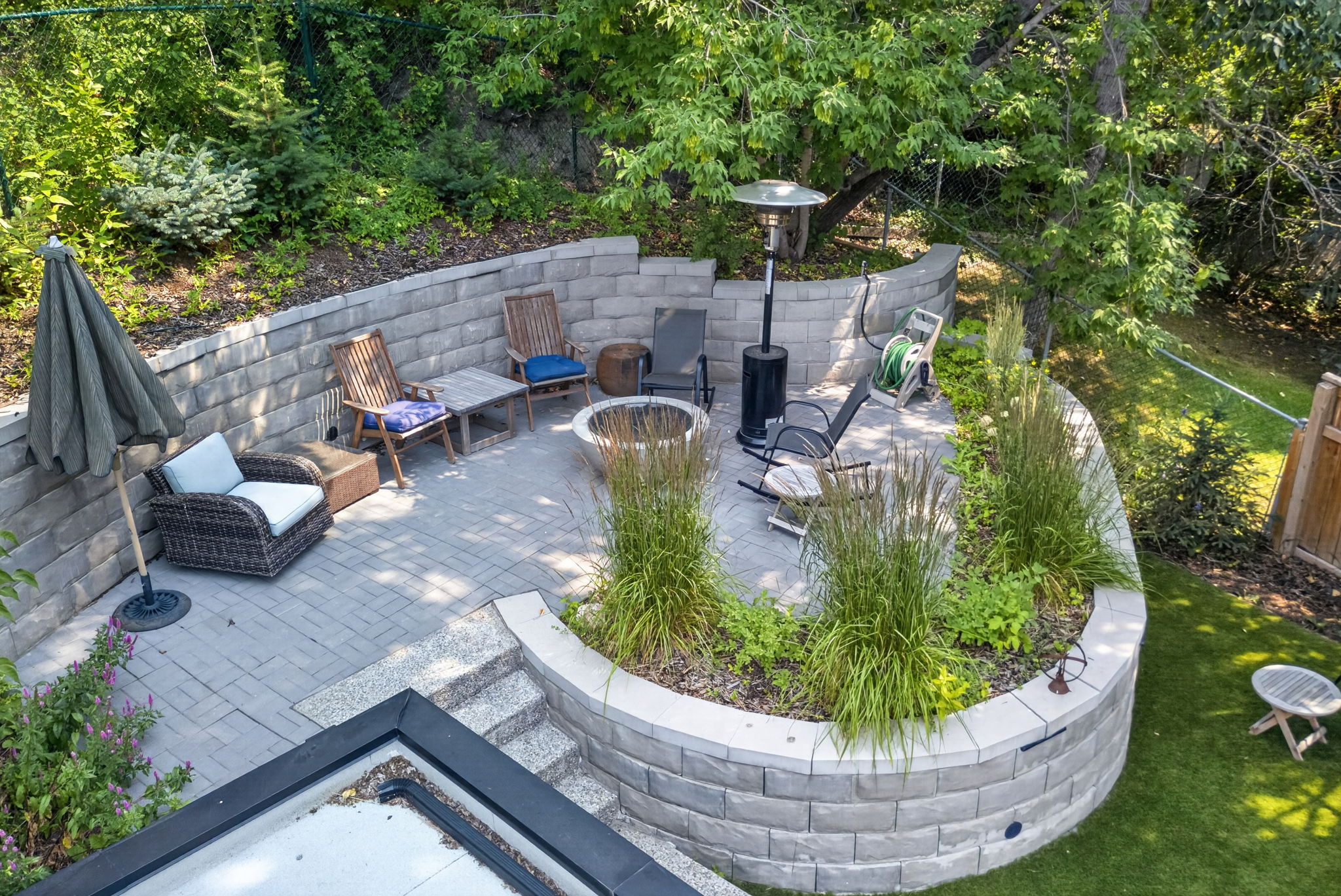 Terraced stone gardens with a firepit lounge