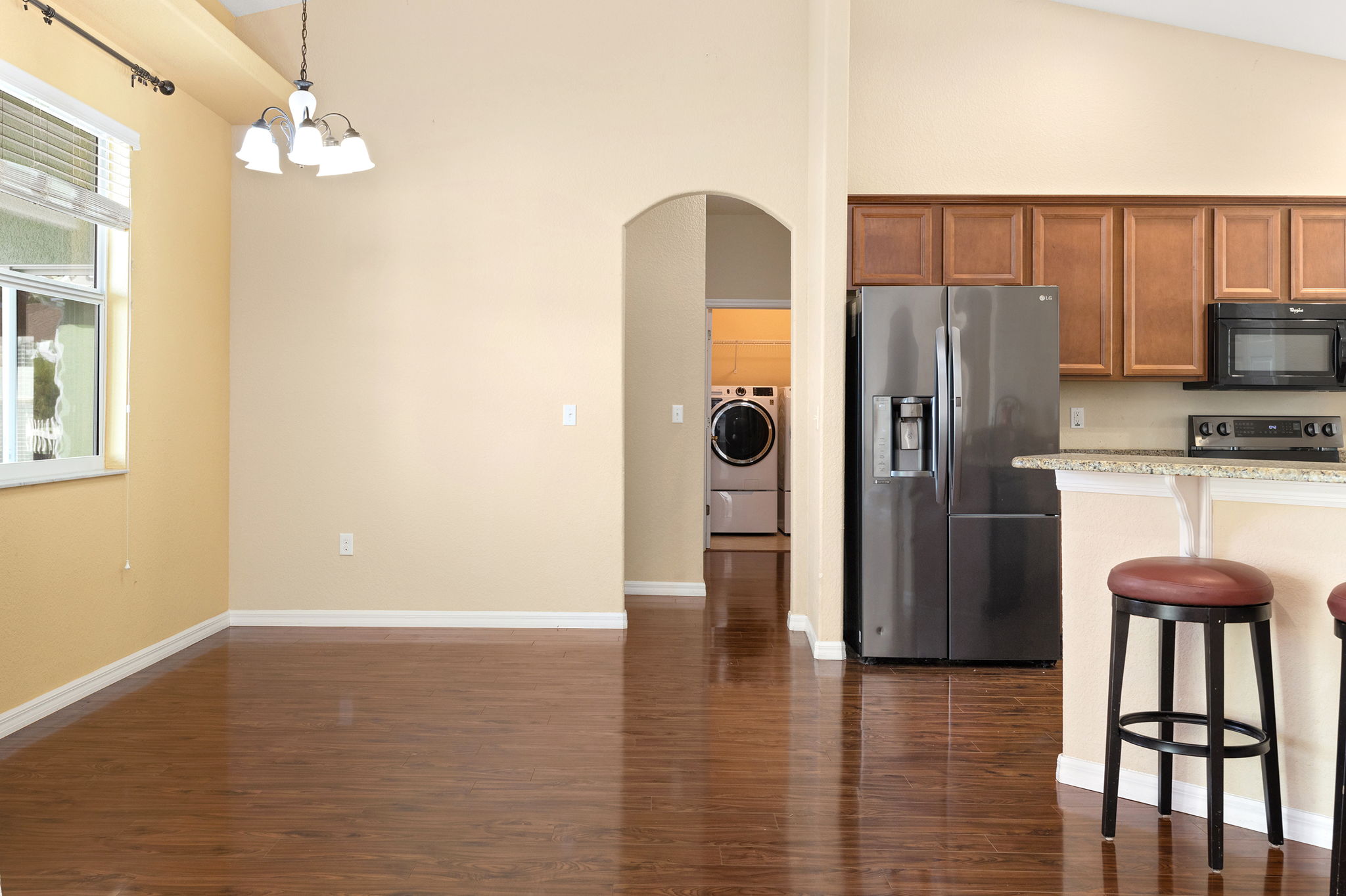 Casual Dining Area On Left With Kitchen On Right; Door Leads To Garage, Half Bath, Laundry Room, And Primary Bedroom