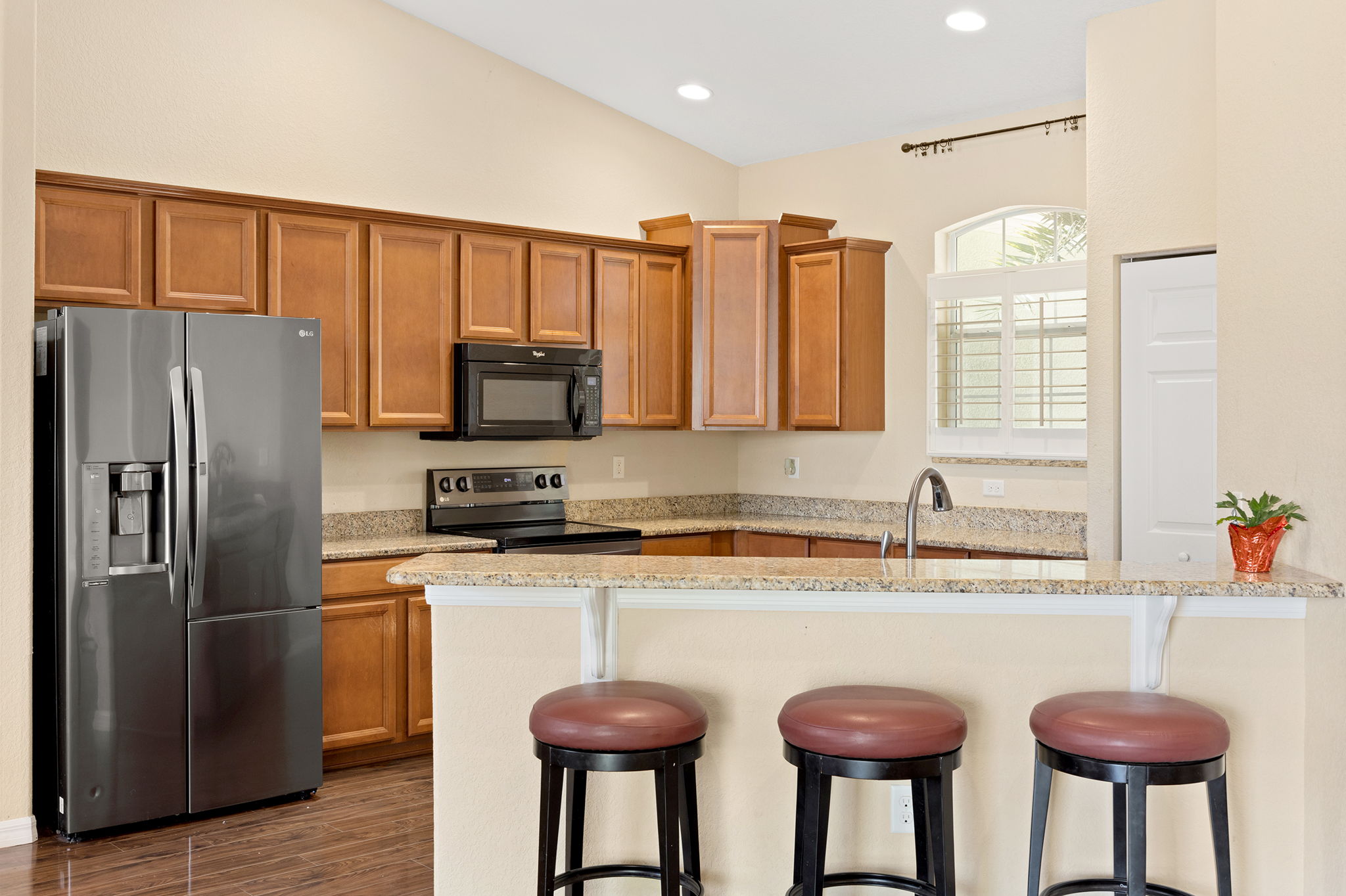 Kitchen With Breakfast Bar, Granite Countertops, And Matching Black Appliances