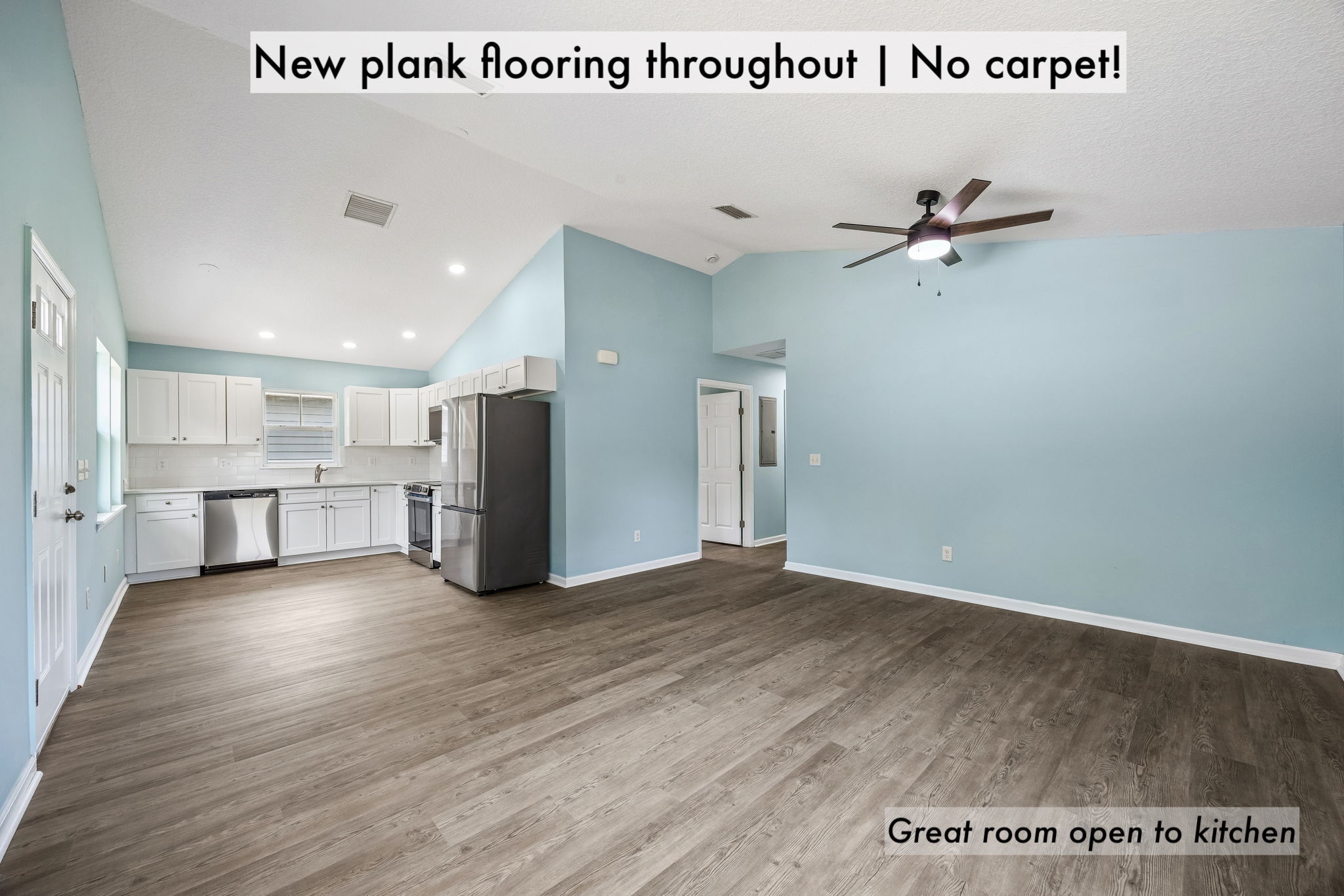 New plank flooring runs throughout with no carpet, creating a clean, cohesive flow into the kitchen