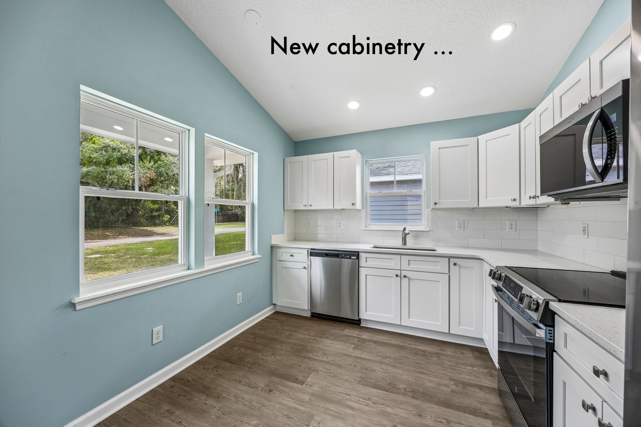 The renovated kitchen pairs crisp new cabinetry with abundant natural light and a practical, efficient layout ...