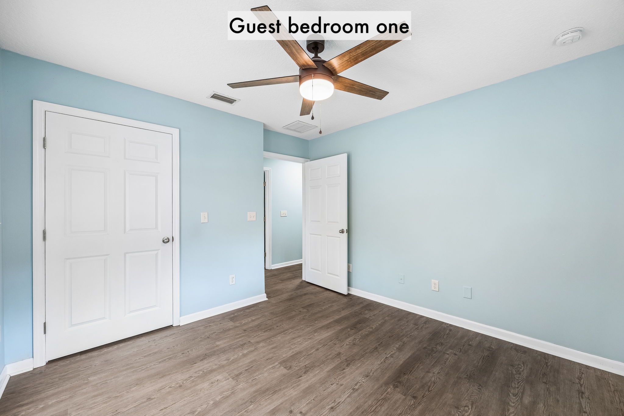 A ceiling fan, plank flooring and a full closet make this a practical and inviting guest retreat …