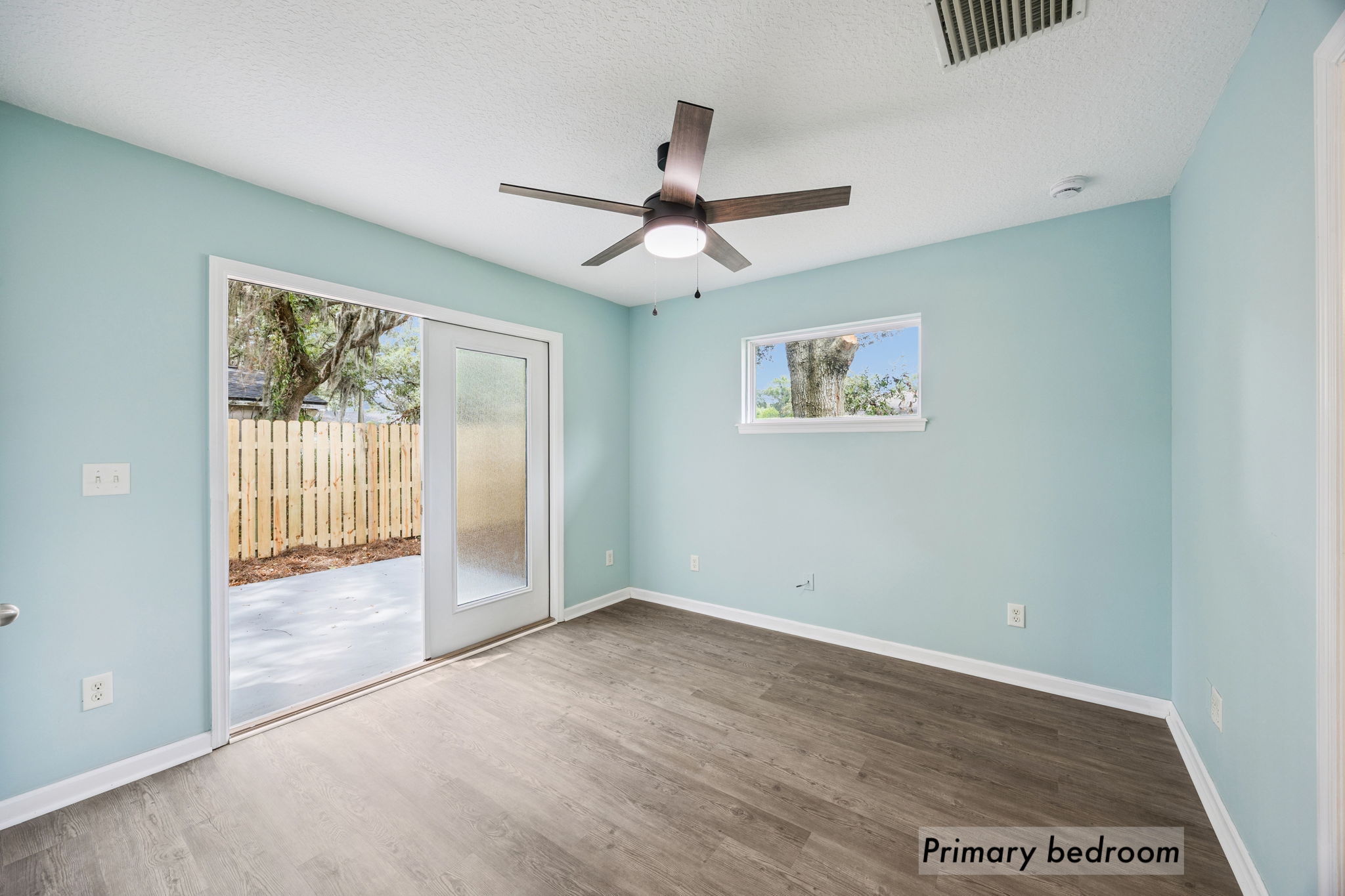 … while a ceiling fan, plank flooring and soft natural light create a comfortable private retreat