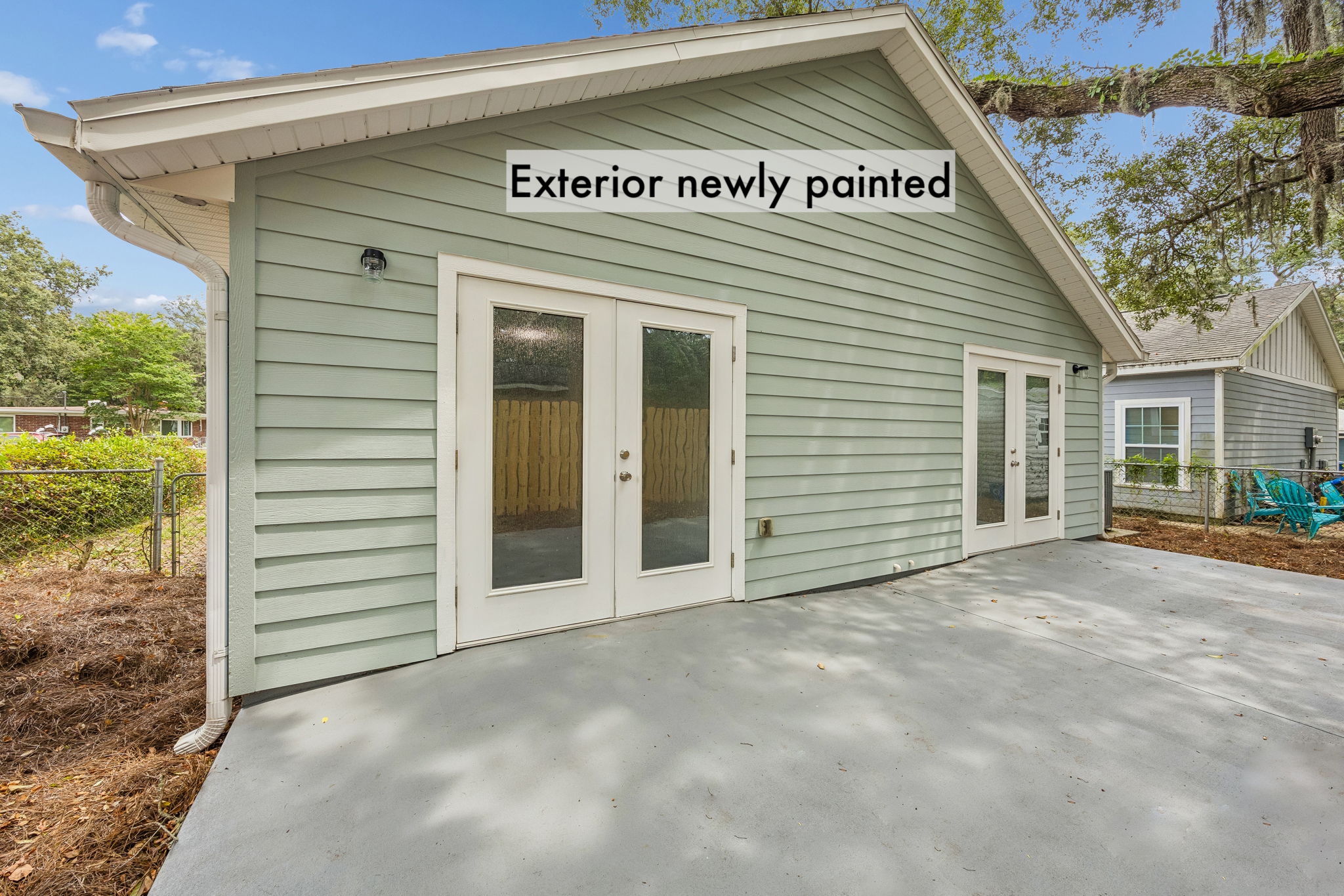 Fresh exterior paint gives the cottage a crisp finish, while two sets of French doors open to the patio