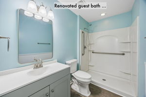 The renovated guest bath includes a new vanity, updated lighting and an easy-access walk-in shower