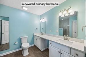 The renovated primary bath features dual vanities, updated lighting and abundant counter space