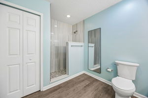 A tiled walk-in shower adds a clean, modern finish, with nearby closet storage completing the layout