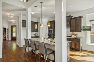 Handscraped hardwoods throughout downstairs showcased below the custom cabinetry and lighting