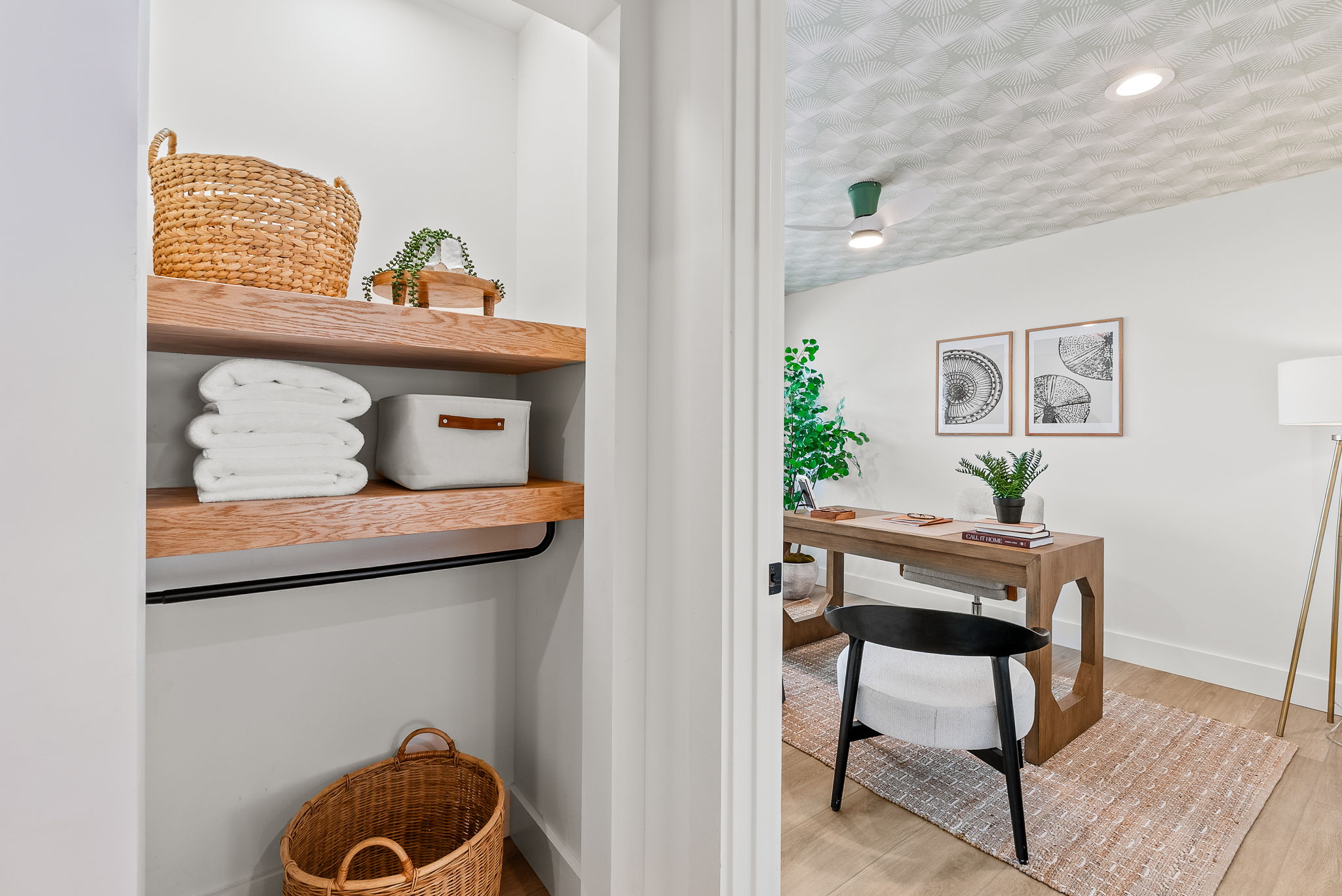 The first of four bedrooms in the main home gets plenty of natural light, perfect for a home office. The patterned ceiling covering elevates the space.