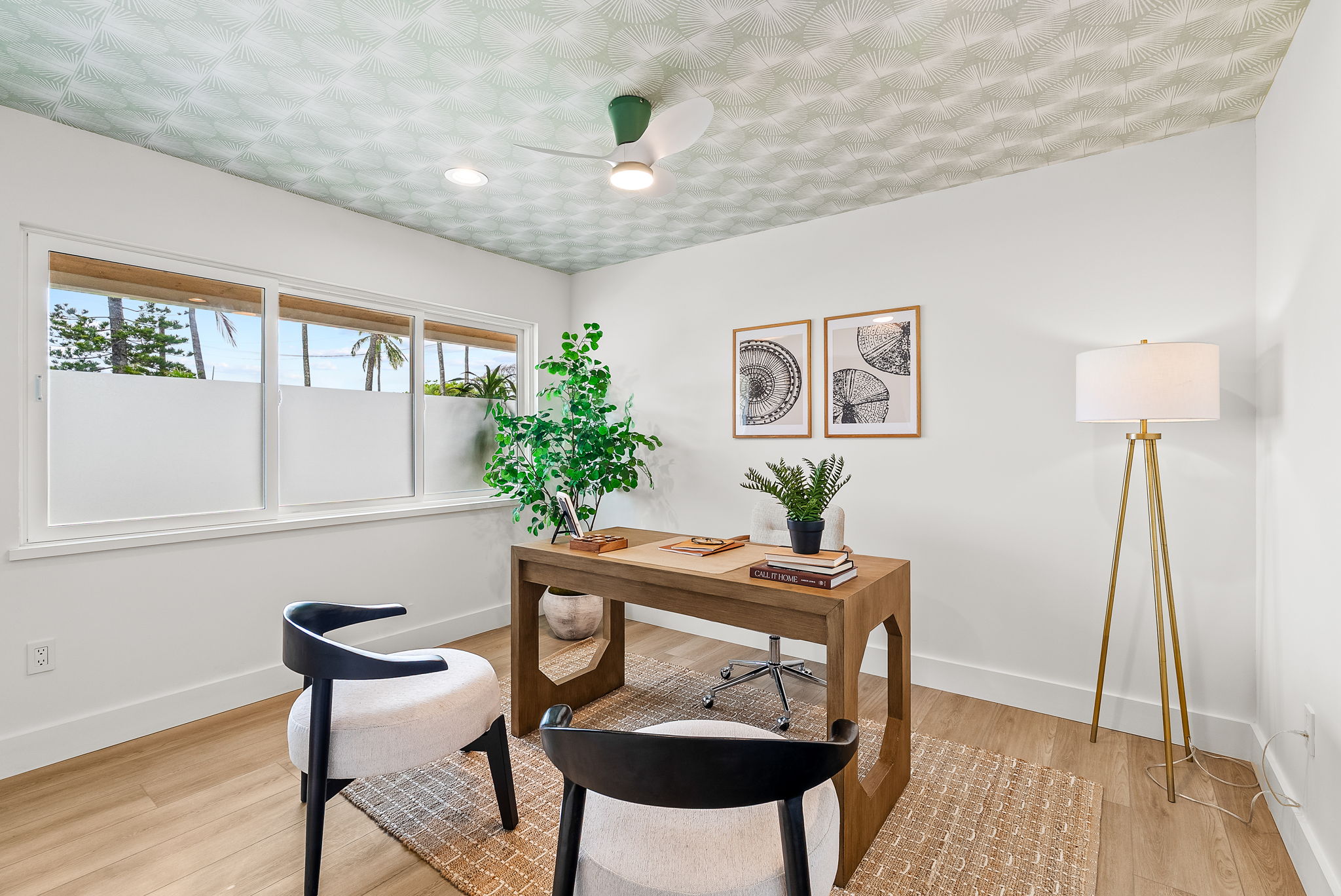 The first of four bedrooms in the main home gets plenty of natural light, perfect for a home office. The patterned ceiling covering elevates the space.