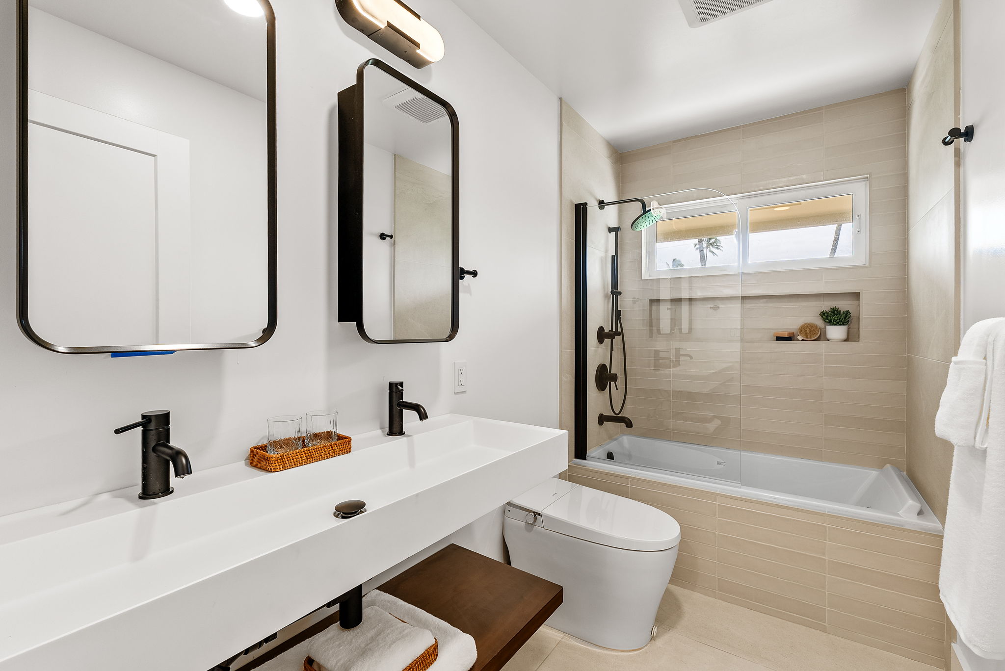 The first of three main residence baths features a tub, trough sink with dual faucets and designer fixtures throughout.