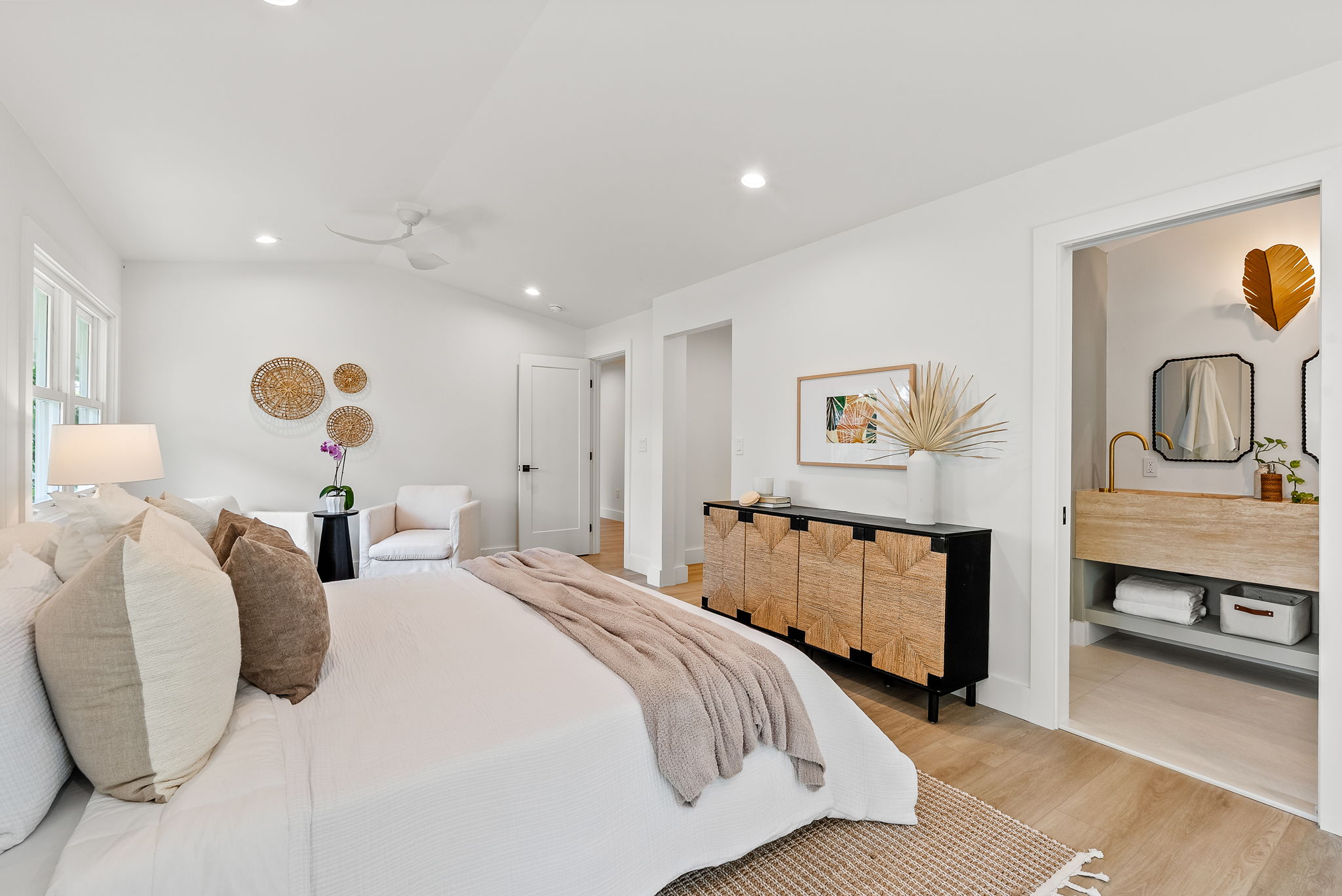 The primary bath vanity is a work of art - cut from a single piece of travertine, this dual vanity is made completely of natural stone. Not shown here - the back wall will be adorned with a custom cut mirror with a leaf-shaped metal light fixture, fitting for this nature inspired home.