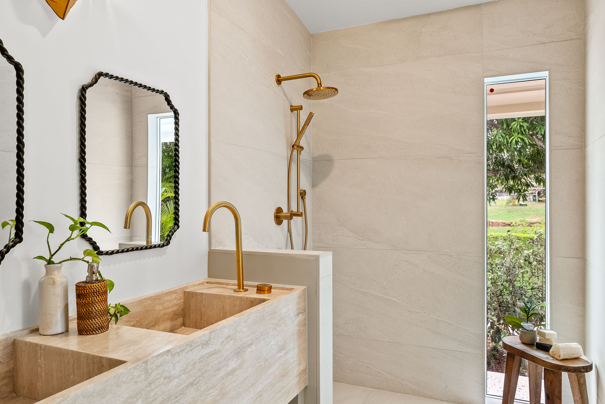 The primary bath vanity is a work of art - cut from a single piece of travertine, this dual vanity is made completely of natural stone. Not shown here - the back wall will be adorned with a custom cut mirror with a leaf-shaped metal light fixture, fitting for this nature inspired home