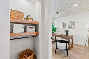 The first of four bedrooms in the main home gets plenty of natural light, perfect for a home office. The patterned ceiling covering elevates the space.