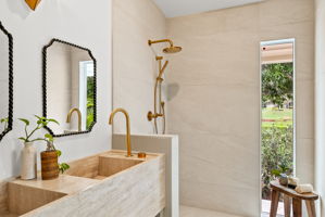 The primary bath vanity is a work of art - cut from a single piece of travertine, this dual vanity is made completely of natural stone. Not shown here - the back wall will be adorned with a custom cut mirror with a leaf-shaped metal light fixture, fitting for this nature inspired home