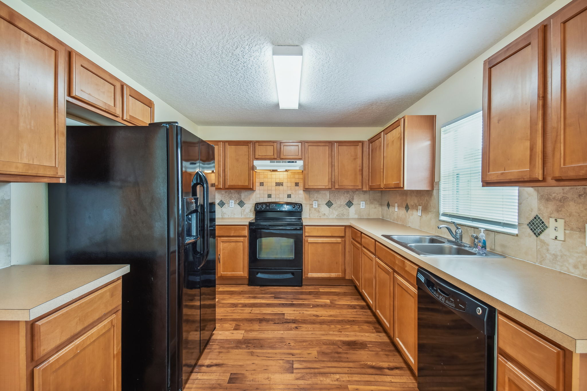 Maple cabinets and vinyl "wood" look flooring in the kitchen