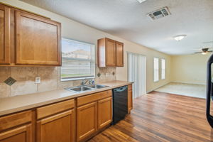 Kitchen has tiled backsplash and all black appliances