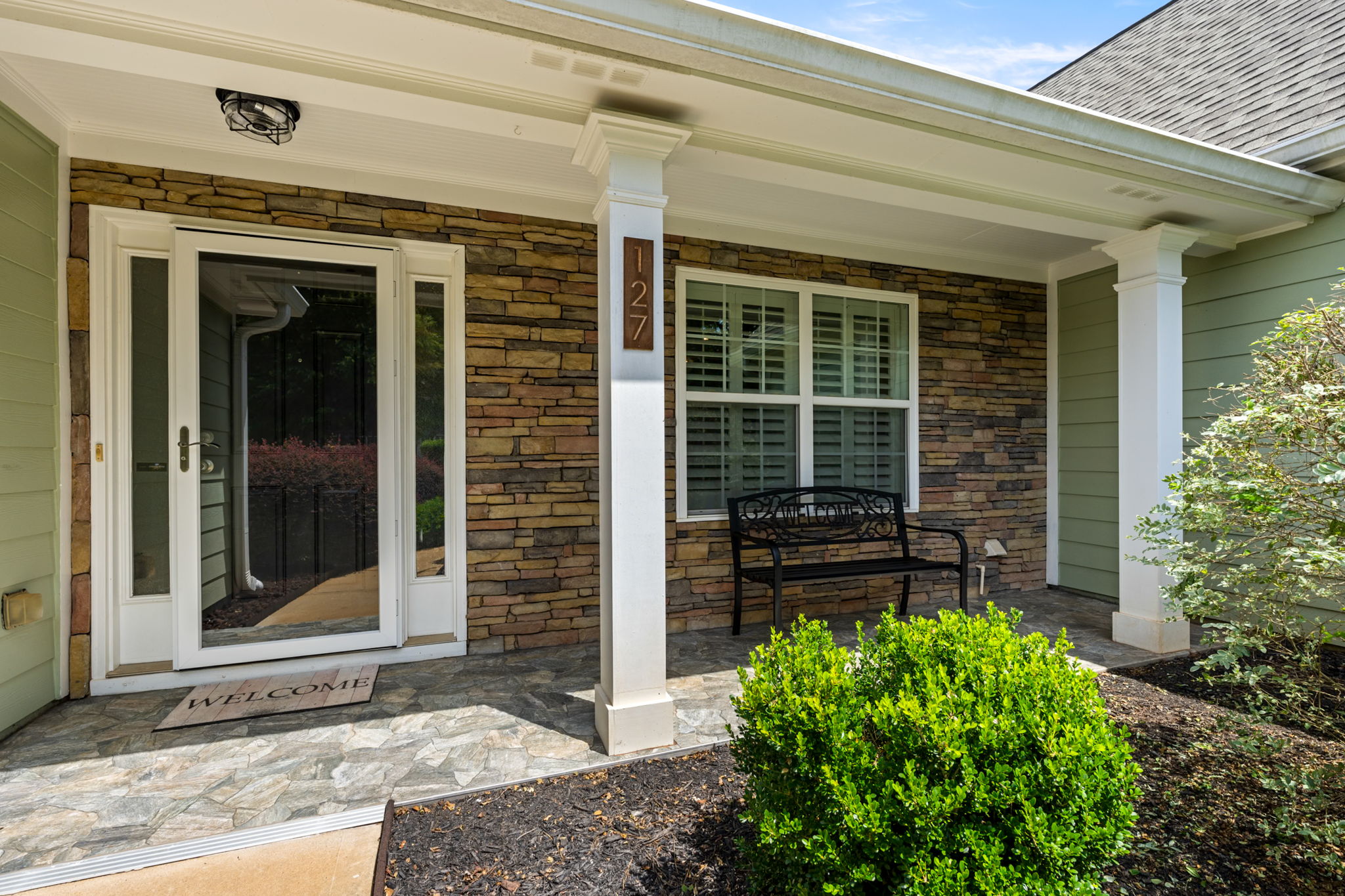 Covered front porch & 'stone' patio.