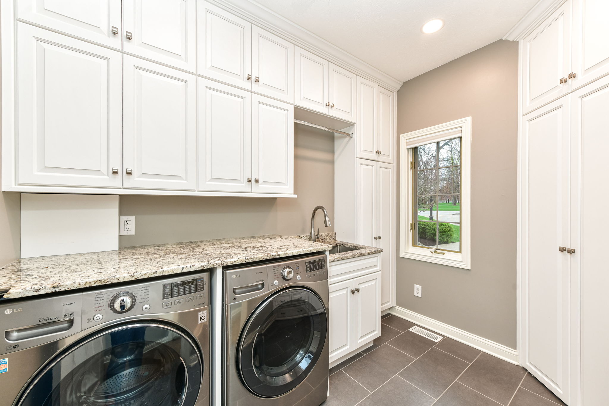 Large Laundry Room with Custom Cabinets and Beautiful Tile Floors