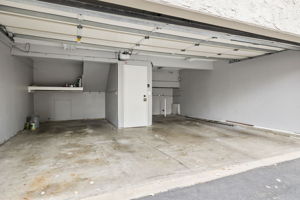 Interior view of the oversized 2-car attached garage with direct access into the unit, auto opener, and side-by-side laundry area & connections