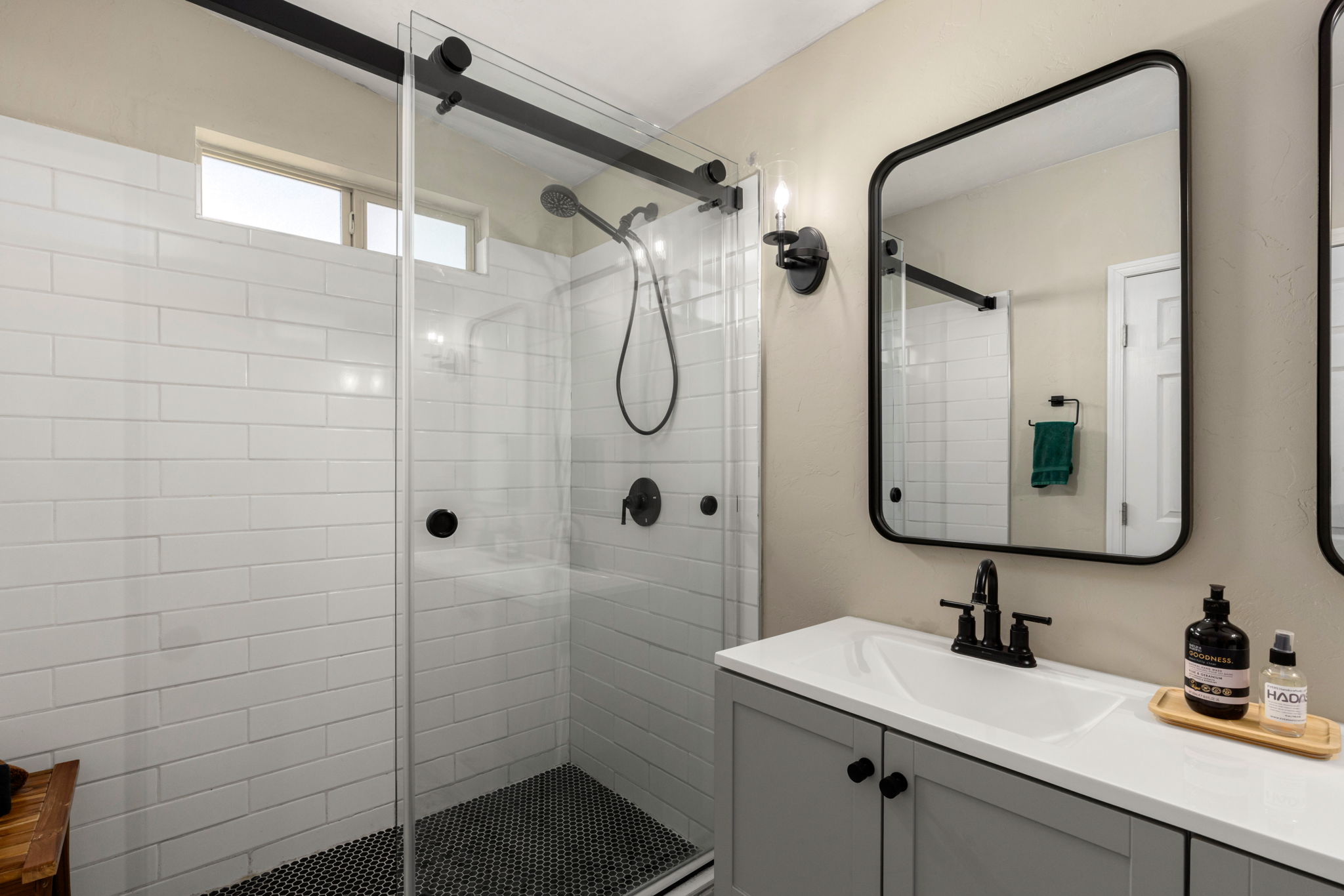 Tile walk in shower with glass sliding door.