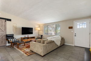 Spacious living area with neutral ceramic tile throughout the living space.