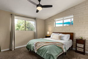 Third bedroom with ceiling fan, carpet and walk in closet.