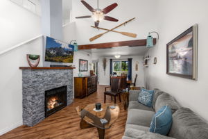 Light, bright & open living room w/vaulted ceiling and fan.