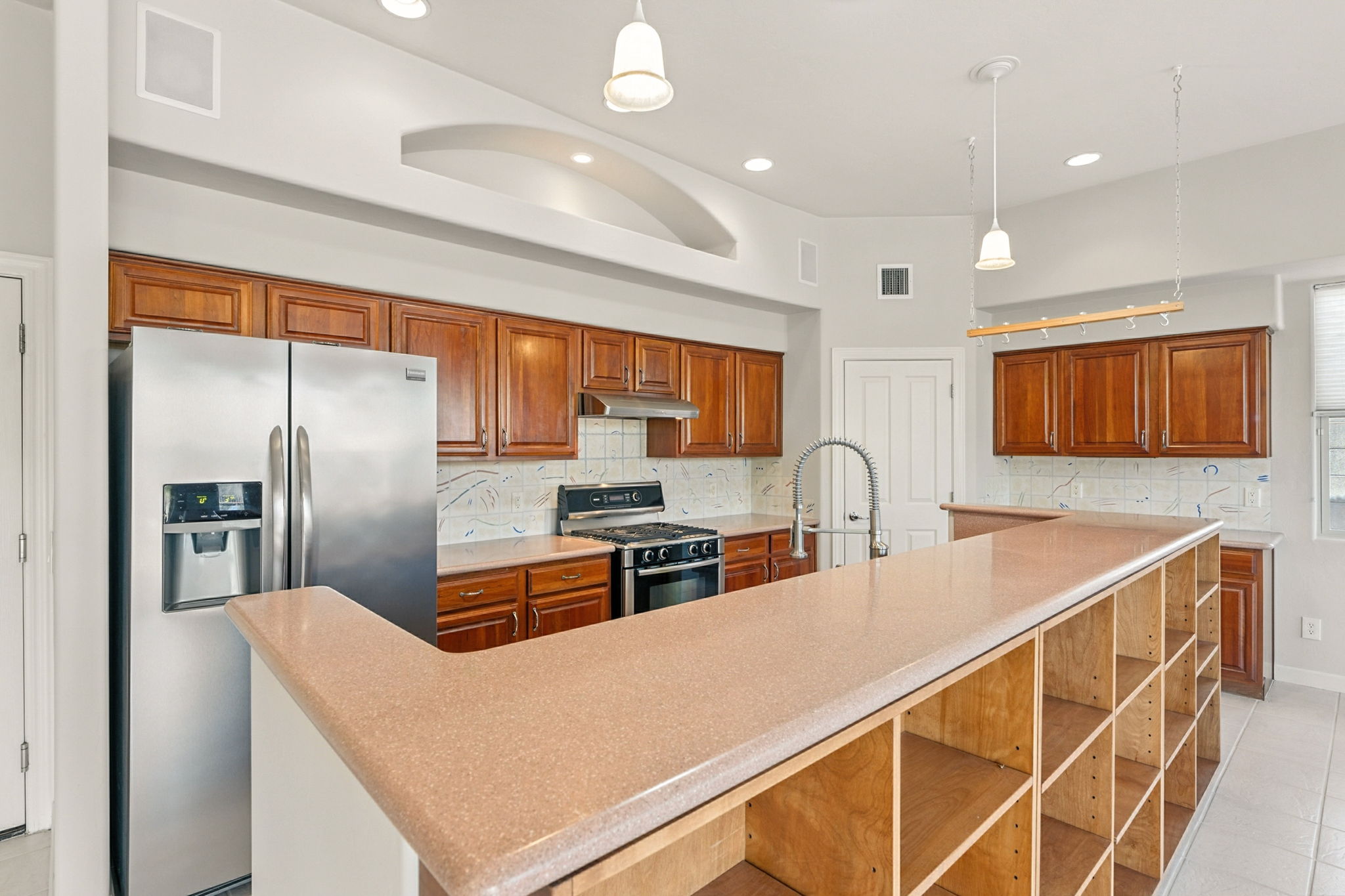 The freestanding island with custom built-in shelving provides space for cookbooks and decor