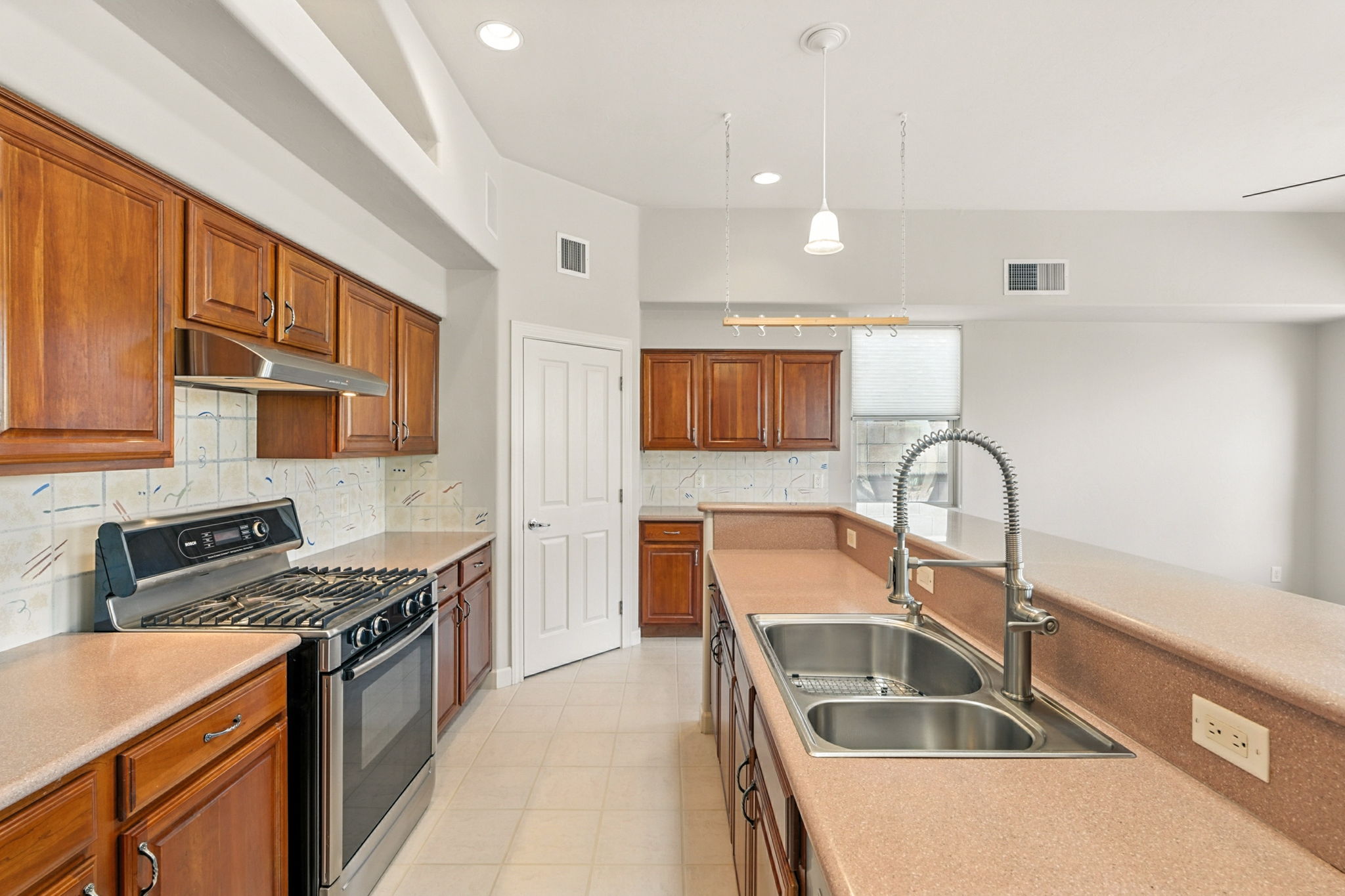 The kitchen is appointed with a corner walk-in pantry, stainless steel appliances, a dual fuel range, and a stainless steel double-basin sink