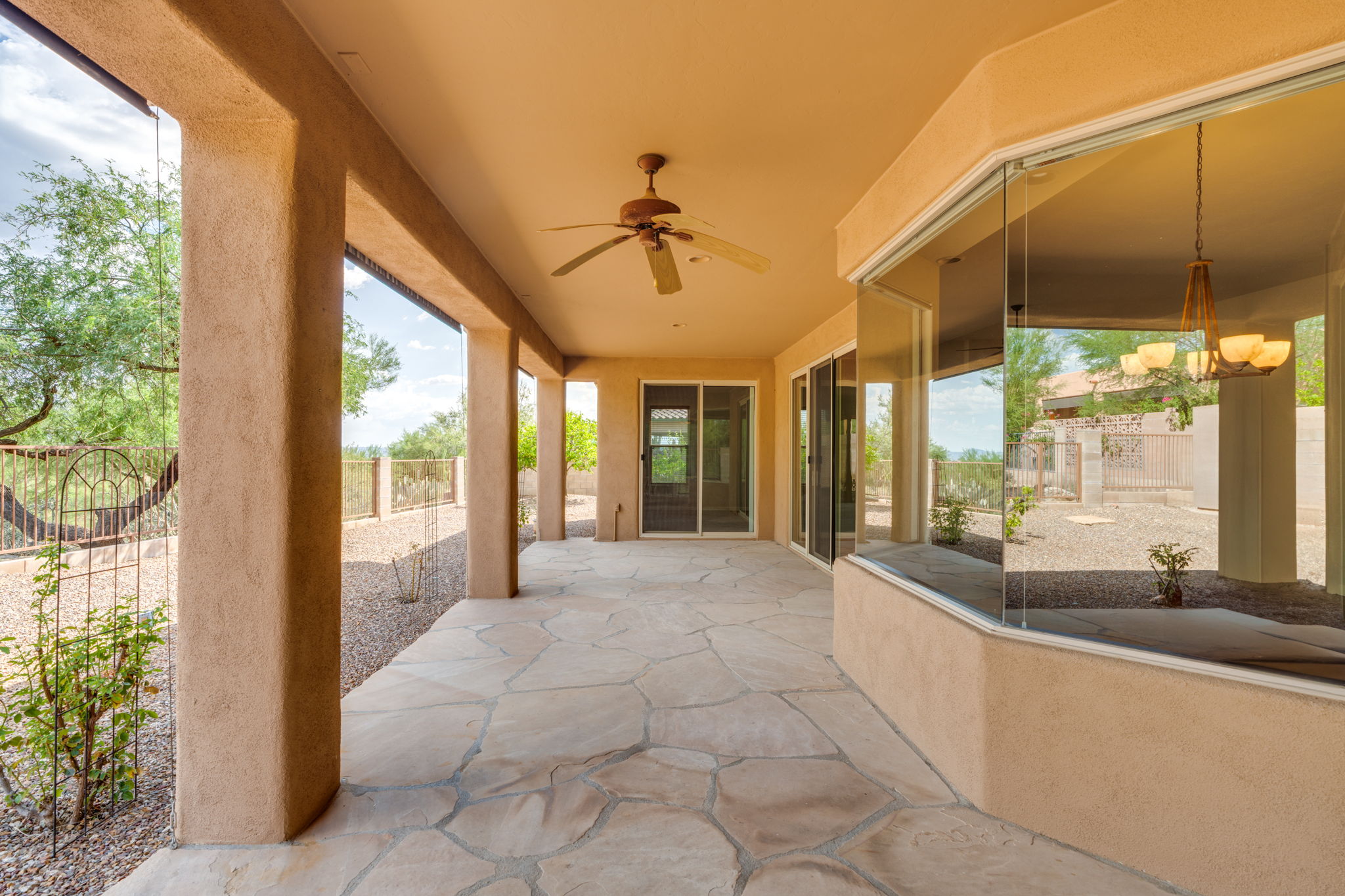 Expansive covered patio featuring flagstone floor and motorized shades