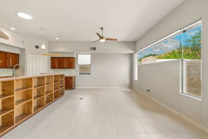 The family room features custom built-in shelves that sit against the kitchen island adjacent to the media wall