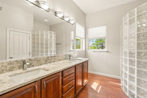 The en suite bath features a double-sink vanity with granite countertop and cherry cabinets
