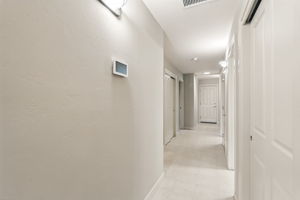 Private hallway leads to the powder room, two bedrooms with shared Jack & Jill bath, laundry room, and single-bay garage entry