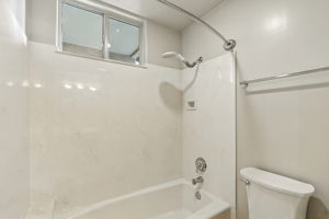 The shared Jack & Jill bath offers a tub/shower combo with pocket door separation from the vanity