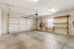 The attached two-car garage offers shelving and a utility sink