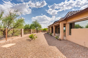 The backyard offers a manicured landscape with citrus trees and a view fence.
